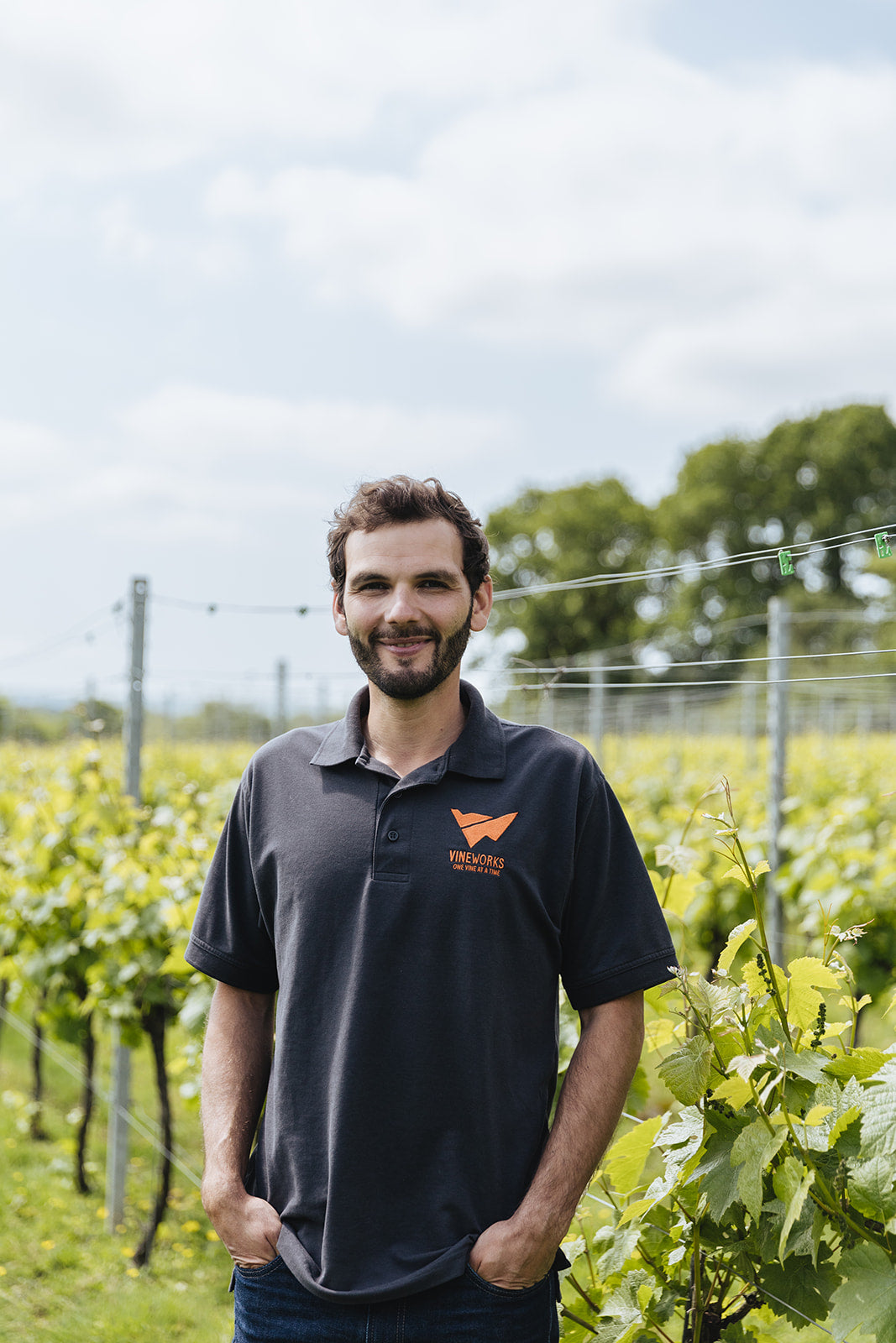 Photo of Tom Reid, Head of Vineyard Services (VineWorks) standing in a vineyard on a sunny day