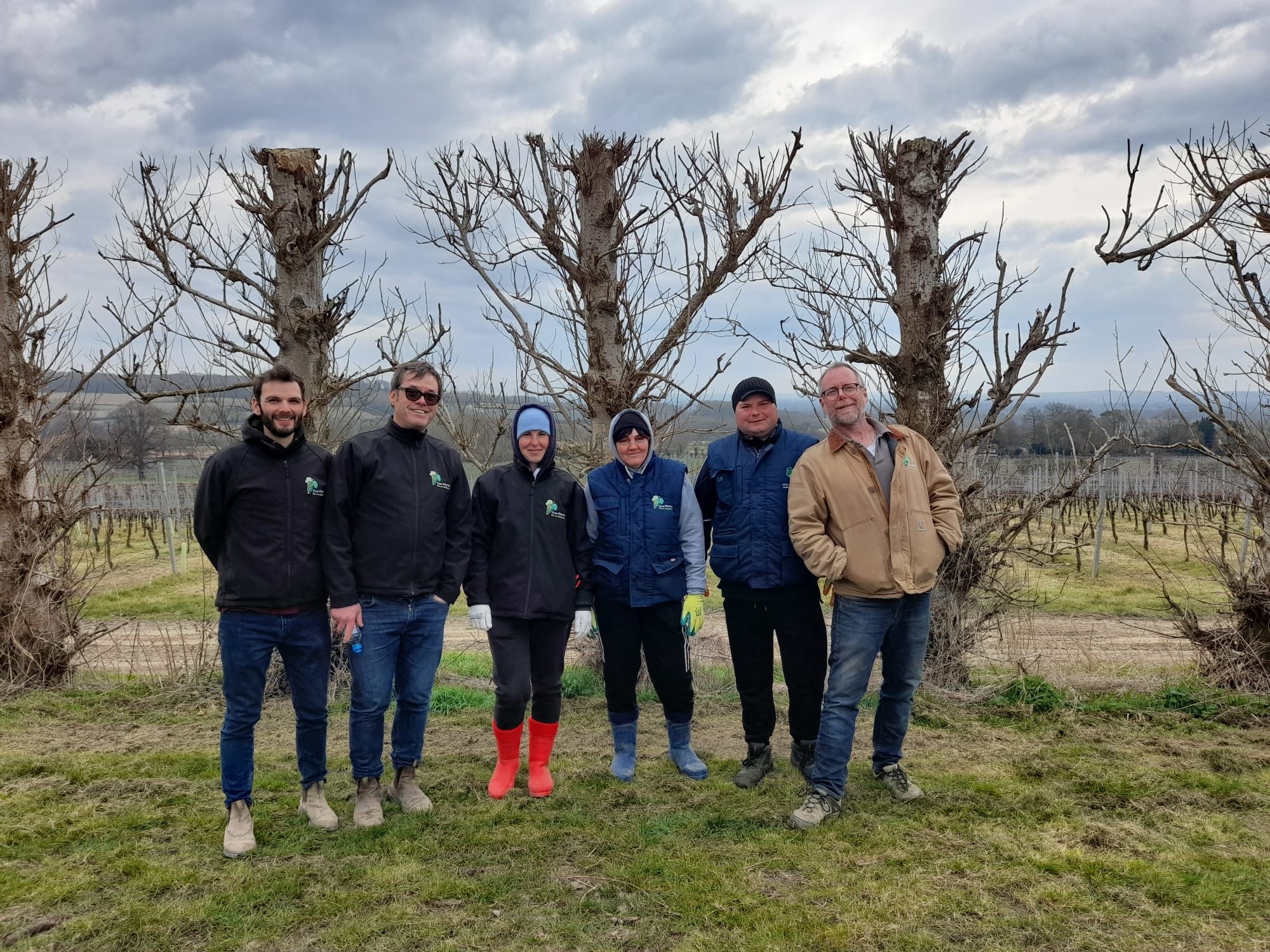 James Dodson, Tom Reid, Charles Martin and three members of the VineWorks vineyard team posing for a group photo in a UK vineyard.
